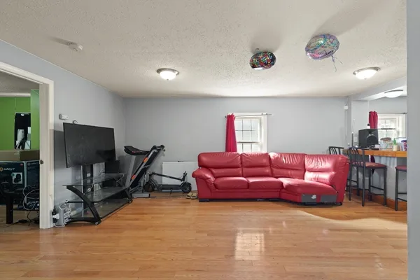 a living room with furniture a wooden floor and a flat screen tv