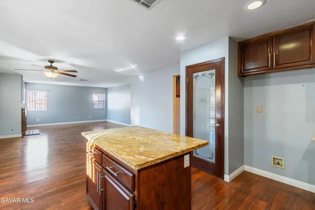 a kitchen with a wooden floor and chandelier