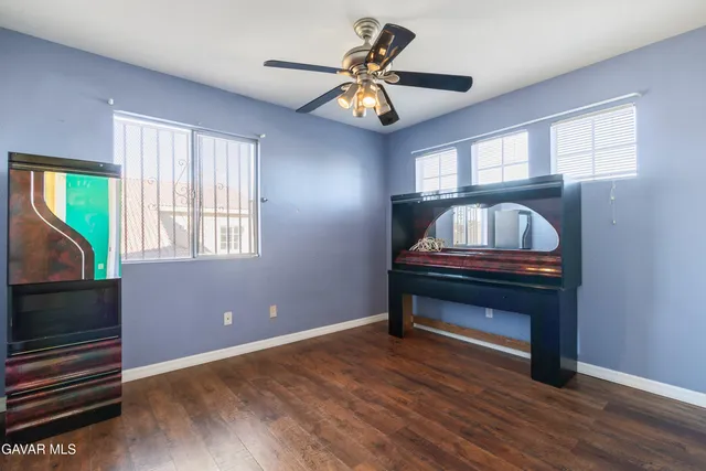a room with chandelier fan and windows