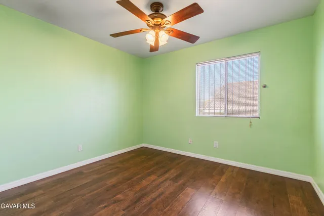 an empty room with a window and ceiling fan