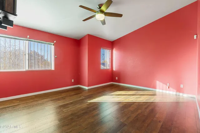 a view of empty room with window and ceiling fan