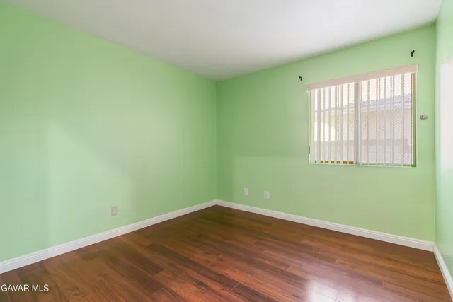 a view of a room with wooden floor and a window