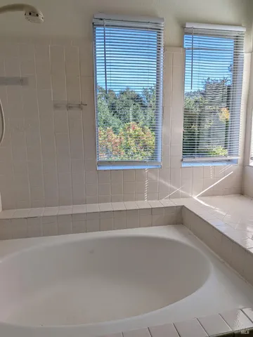 a white bath tub sitting next to a window