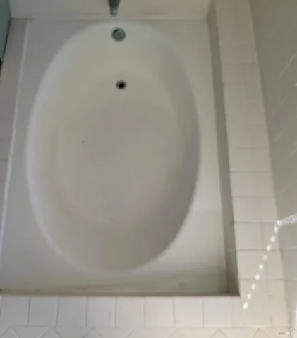 an empty room with wooden floor and a bathroom