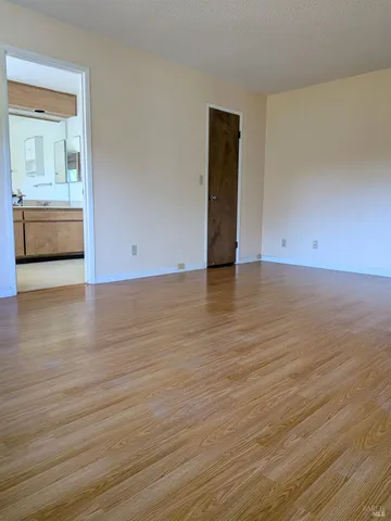 a view of a room with wooden floor and a bathroom