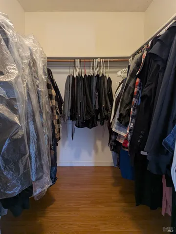 a view of walk in closet with clothes and shoes