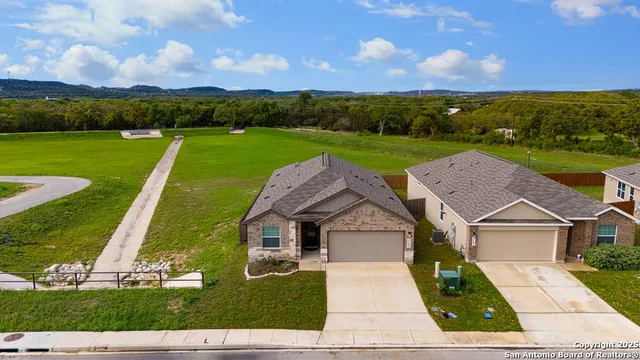 an aerial view of residential houses with outdoor space and swimming pool
