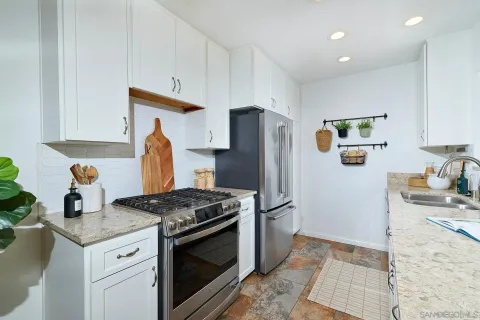 a kitchen with stainless steel appliances granite countertop a refrigerator sink and stove