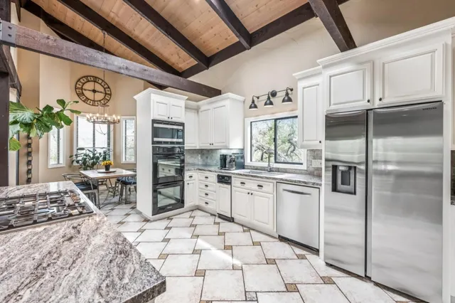 a kitchen with stainless steel appliances granite countertop a refrigerator and a stove top oven
