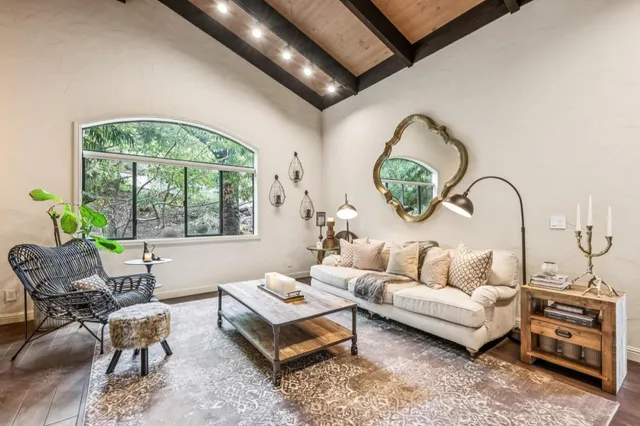 a living room with furniture a table and a large window