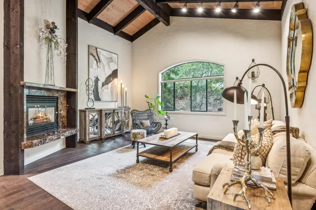 a living room with furniture a fireplace and a chandelier