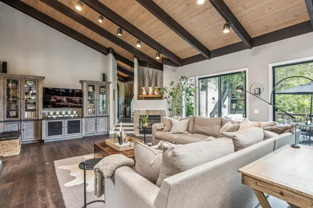 a living room with furniture wooden floor and large window