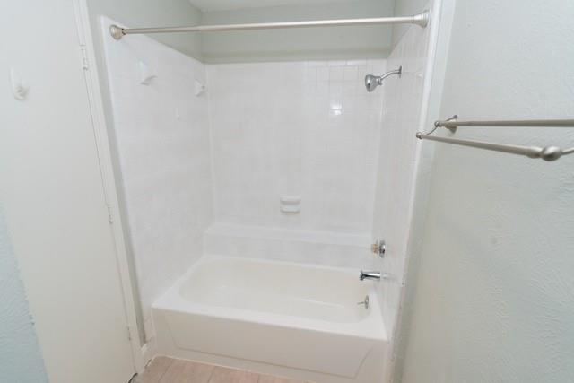 106 Mapleleaf Lane Coppell, TX 75019 - Photo 20 of 36 White tiled bath and shower combination featuring a curved shower rod and chrome fixtures
