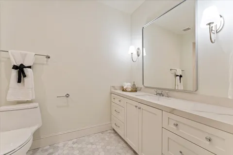 a bathroom with a sink and mirror with toilet