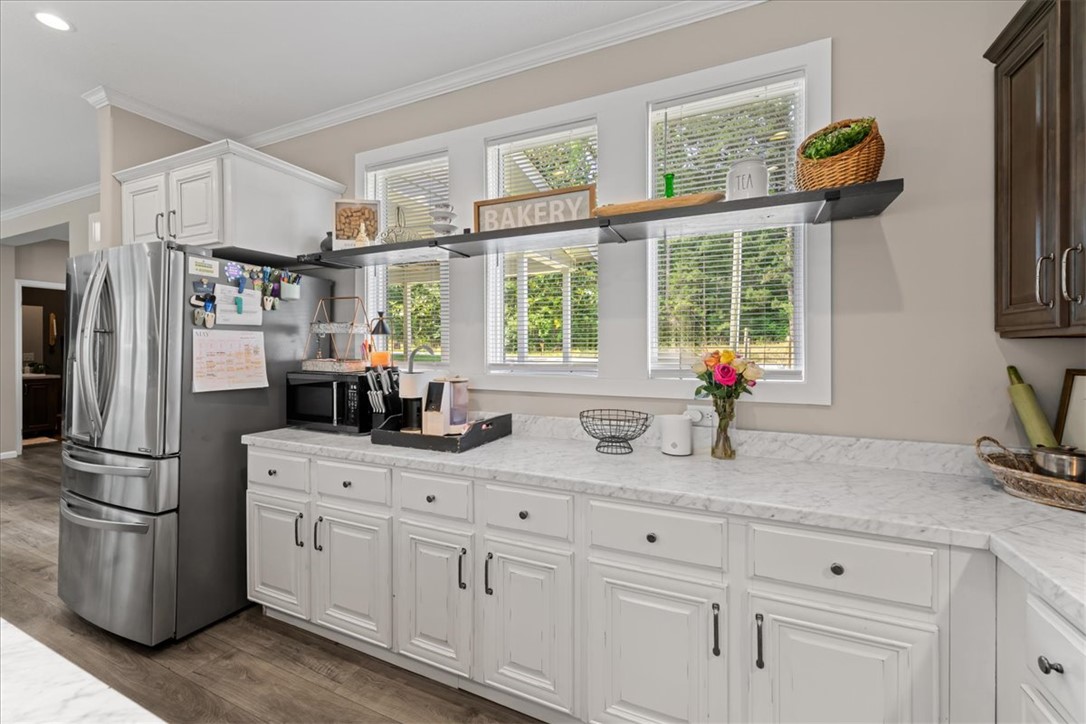 116 Parkview Road Iva, SC 29655 - Photo 8 of 44 A well-appointed kitchen showcasing white cabinetry and durable countertops, illuminated by three windows.