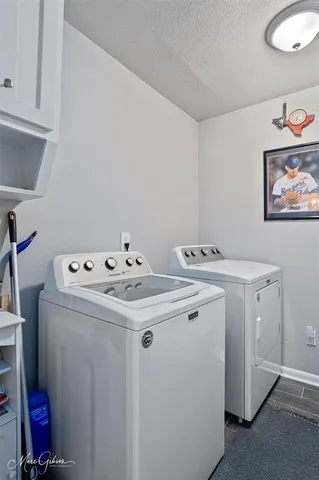 a kitchen with a refrigerator and wooden cabinets