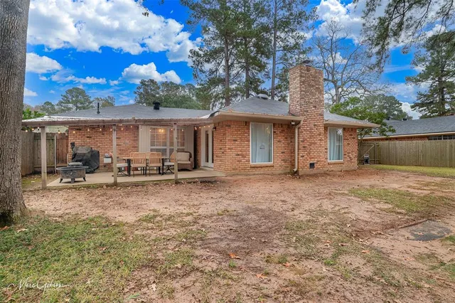 a view of a house with backyard and chairs