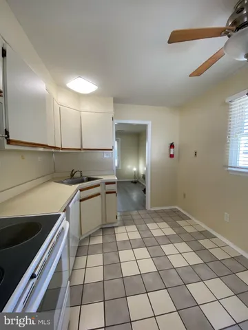 a kitchen with a sink a stove cabinets and utility room