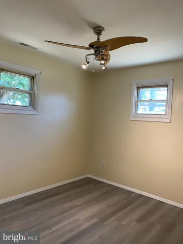 an empty room with a window and wooden floor