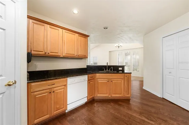 a kitchen with granite countertop wooden cabinets and white appliances