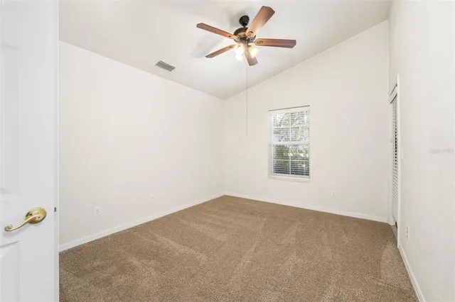 an empty room with a window and a fan