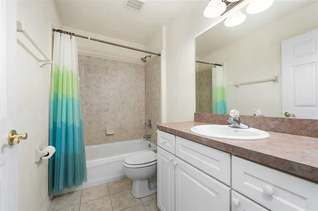 a bathroom with a granite countertop sink a toilet and shower