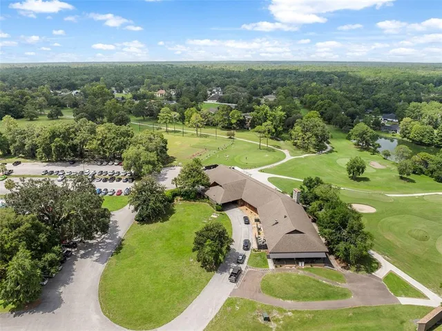 an aerial view of residential houses with outdoor space and trees