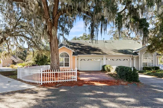 a view of a house with a small yard and wooden fence