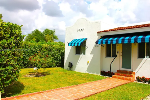 a blue swimming pool is in front of the house