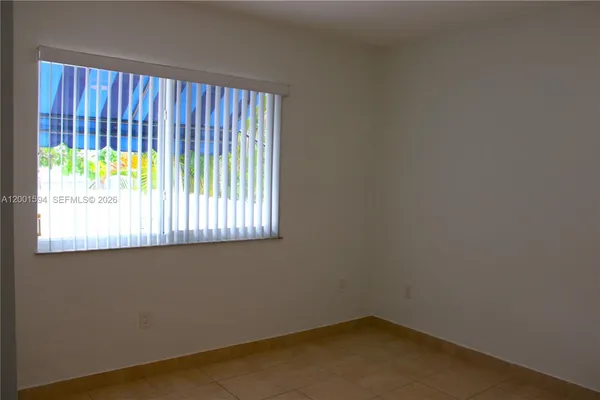 a kitchen with a table chairs microwave and refrigerator