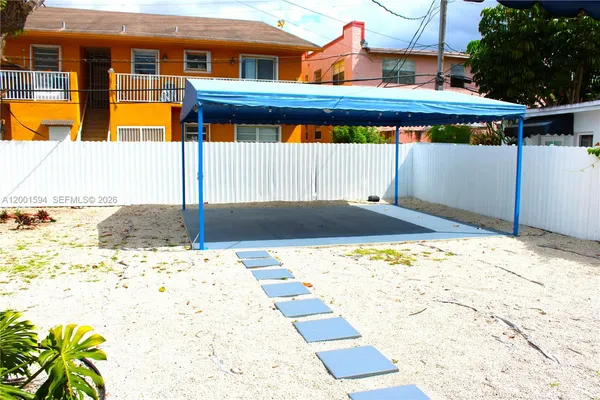 a view of a pathway of a house with wooden fence