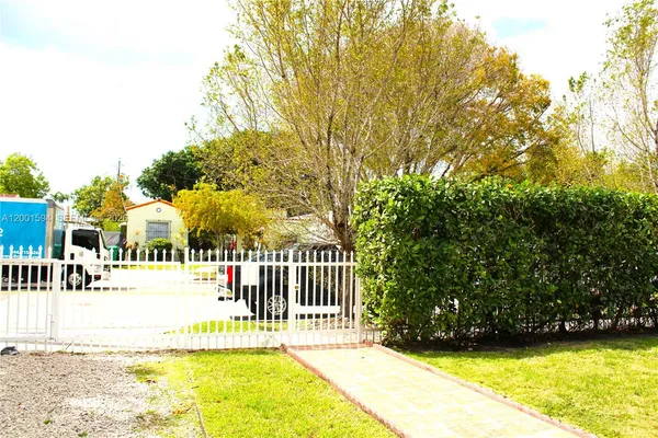 a view of a house with a small yard and fence