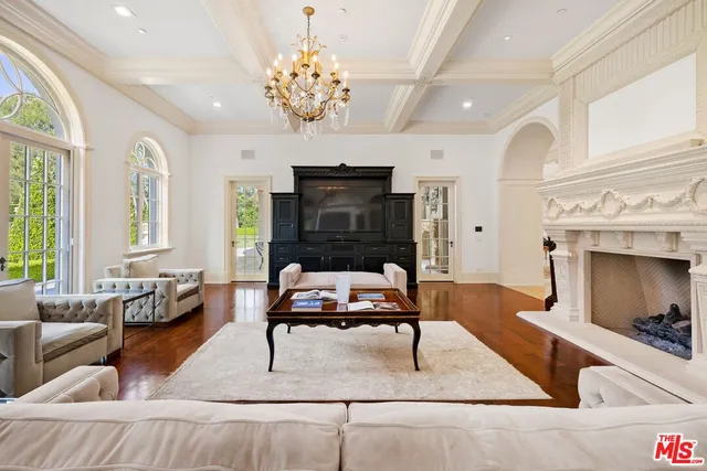 a living room with furniture a fireplace and chandelier