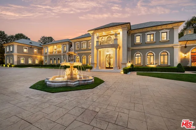 a front view of residential houses with yard and parking