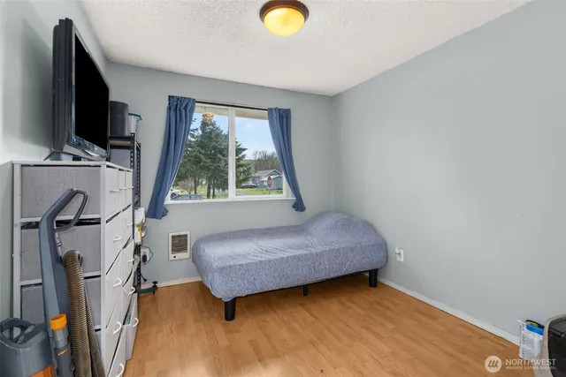 a bedroom with a bed and a flat tv screen on the dresser