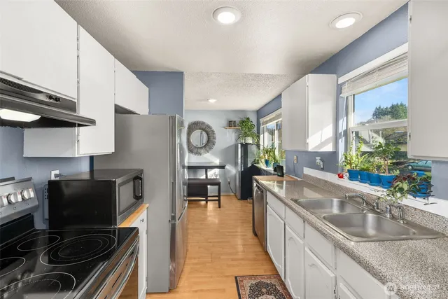 a kitchen with stainless steel appliances granite countertop a sink stove and refrigerator