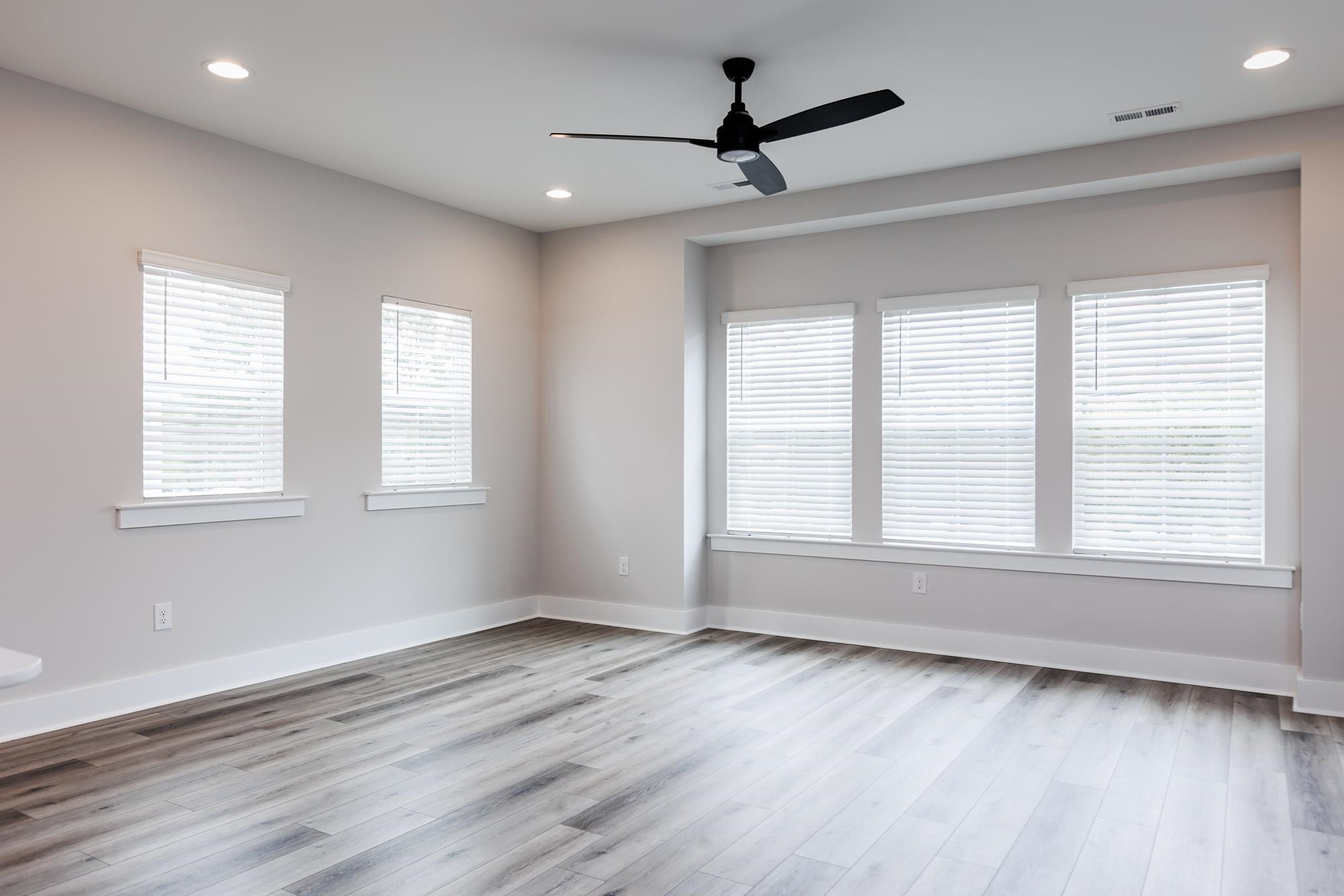 8222 Ebenezer Church Road Raleigh, NC 27613 - Photo 6 of 18 a view of empty room with wooden floor and fan