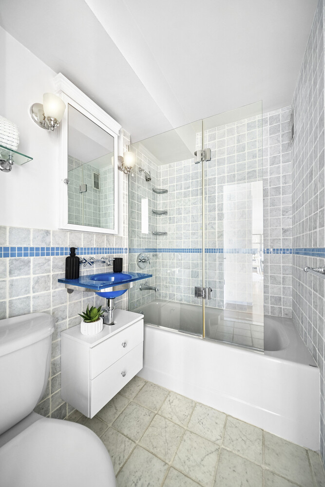 240 East 76th Street, Unit 14G Manhattan, NY 10021 - Photo 4 of 7 a bathroom with a sink toilet and shower