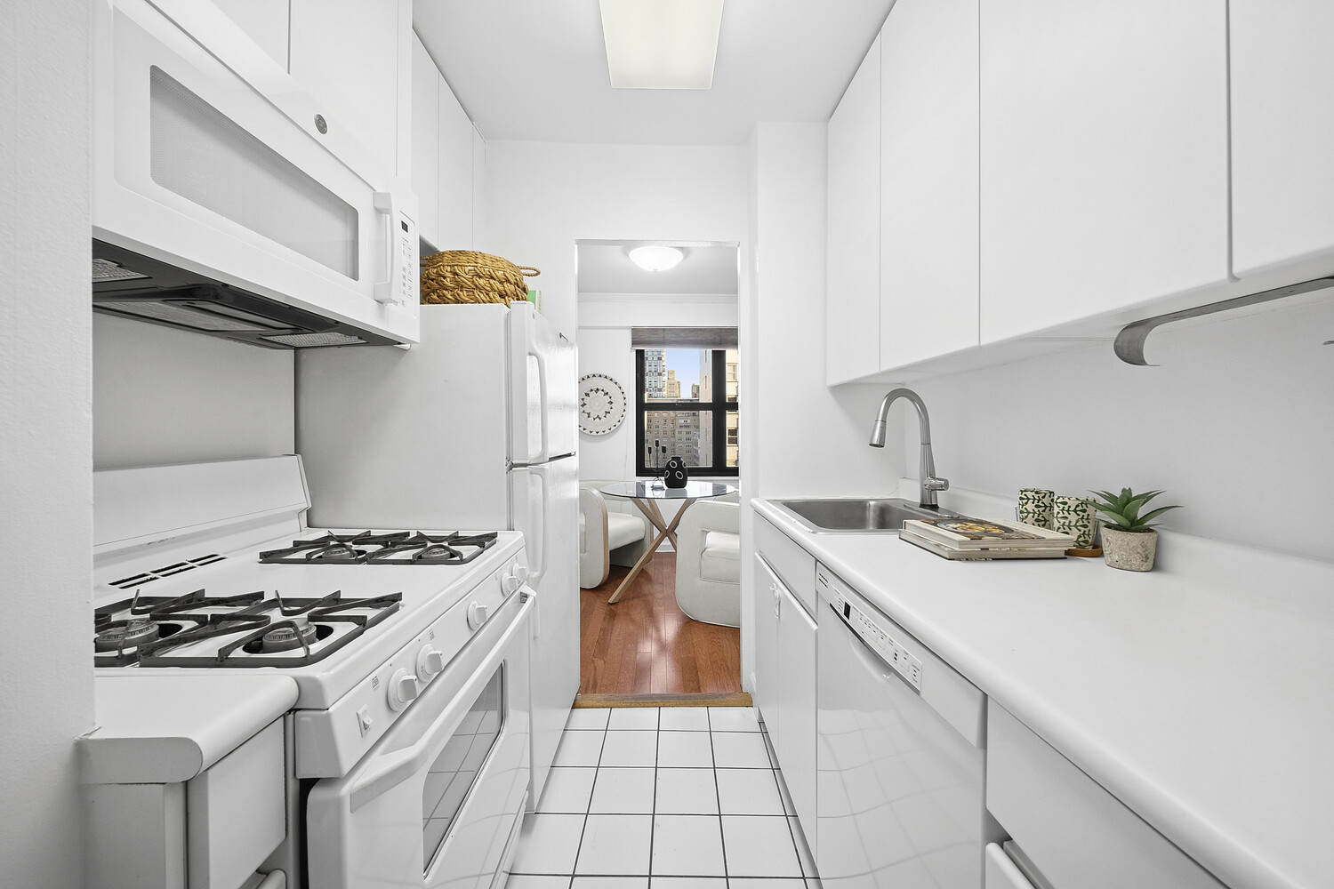 240 East 76th Street, Unit 14G Manhattan, NY 10021 - Photo 5 of 7 a kitchen with a sink a stove and cabinets