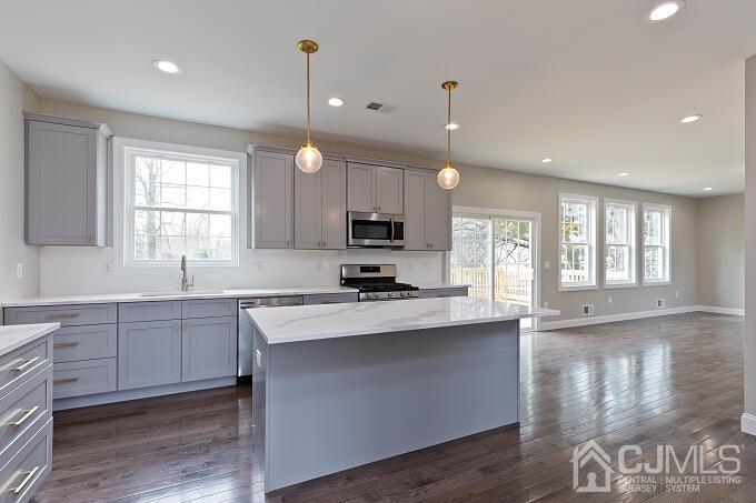 1214 Brookside Road Piscataway, NJ 08854 - Photo 7 of 26 a kitchen with kitchen island granite countertop a stove a sink a center island and a window