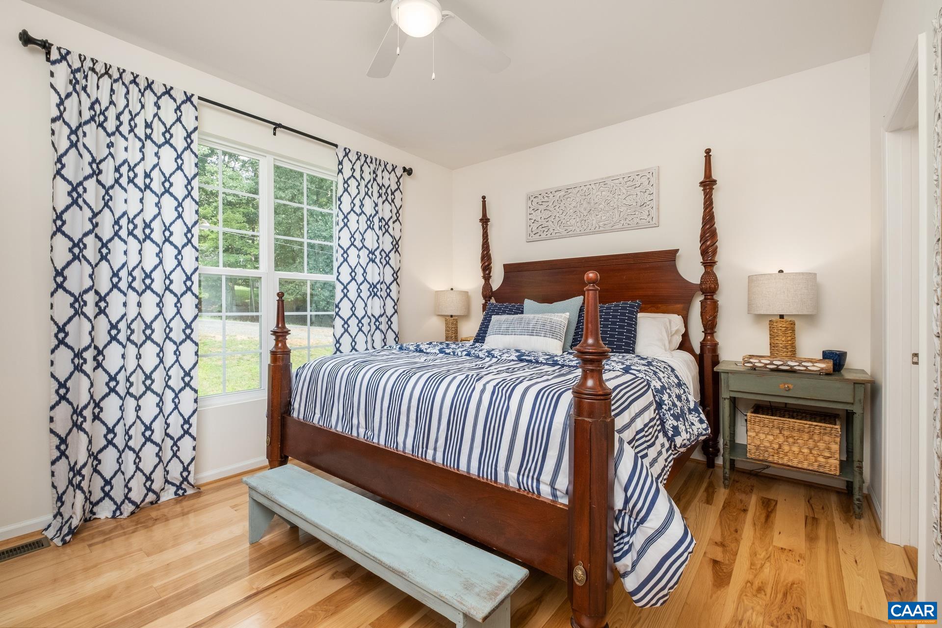 283 Logtrac Road Stanardsville, VA 22973 - Photo 14 of 49 a bedroom with a bed lamp and a large window with wooden floor