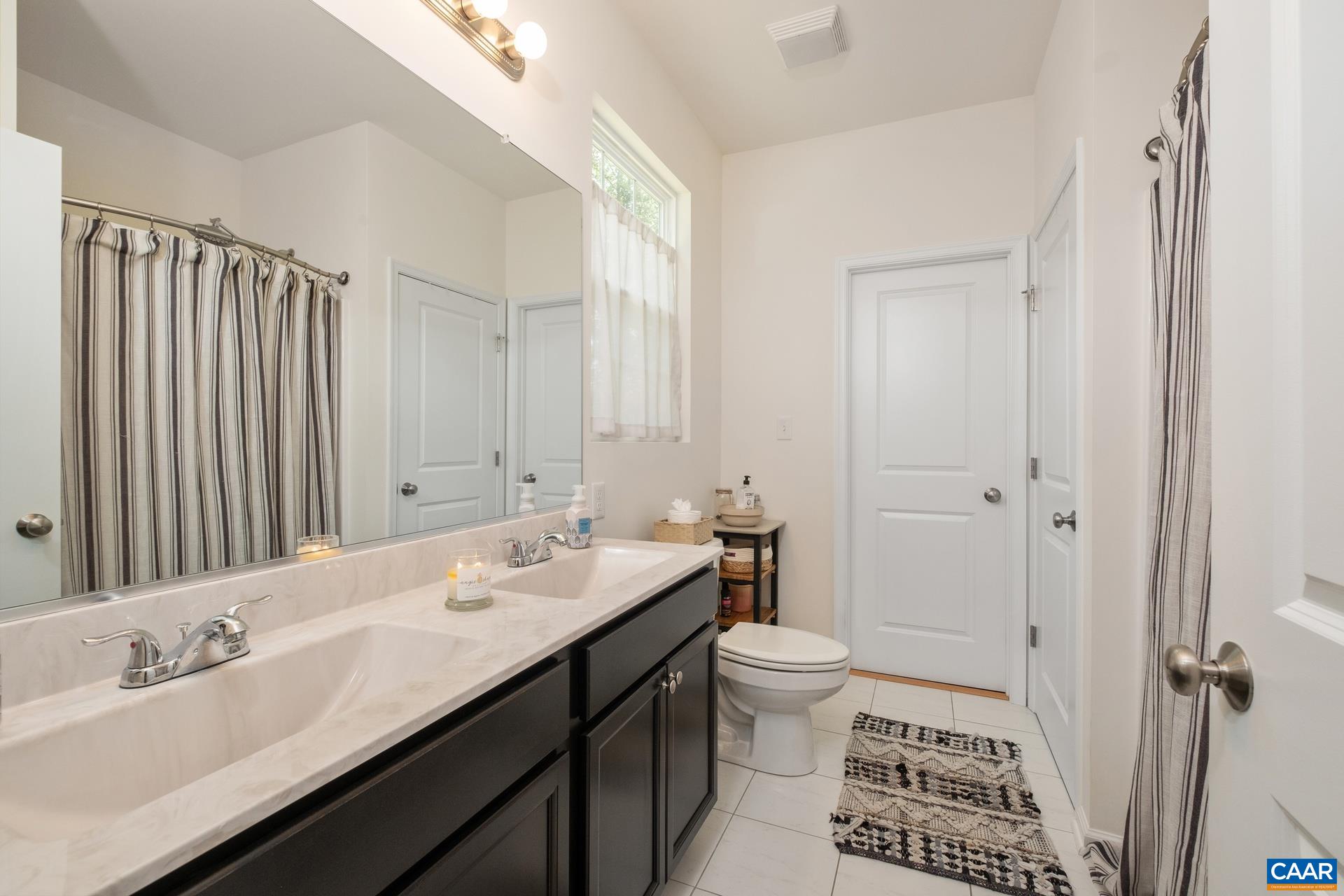 283 Logtrac Road Stanardsville, VA 22973 - Photo 15 of 49 a bathroom with a double vanity sink a toilet and a mirror