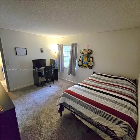 a bedroom with bed and a chandelier