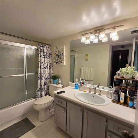 a bathroom with a double vanity sink toilet and shower