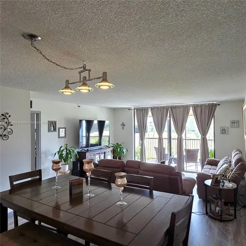 a living room with furniture large window and wooden floor