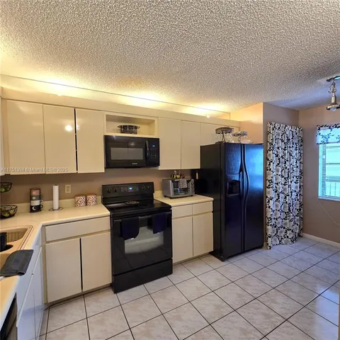 a kitchen with a refrigerator and a stove top oven