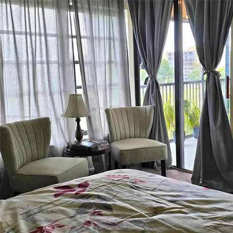 a bedroom with furniture and a large window