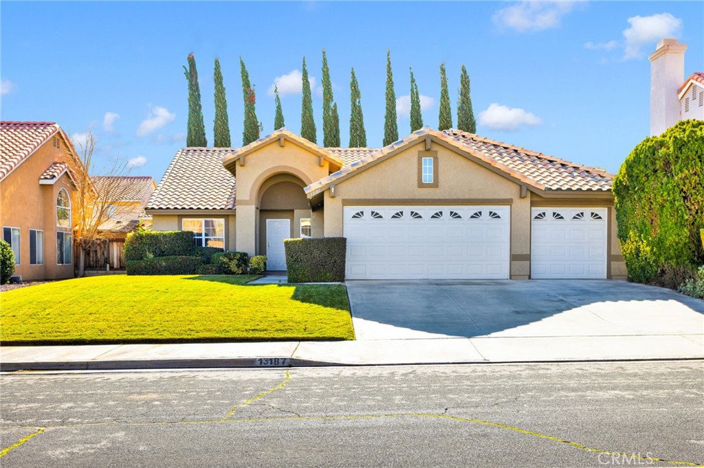 a front view of a house with a yard and trees