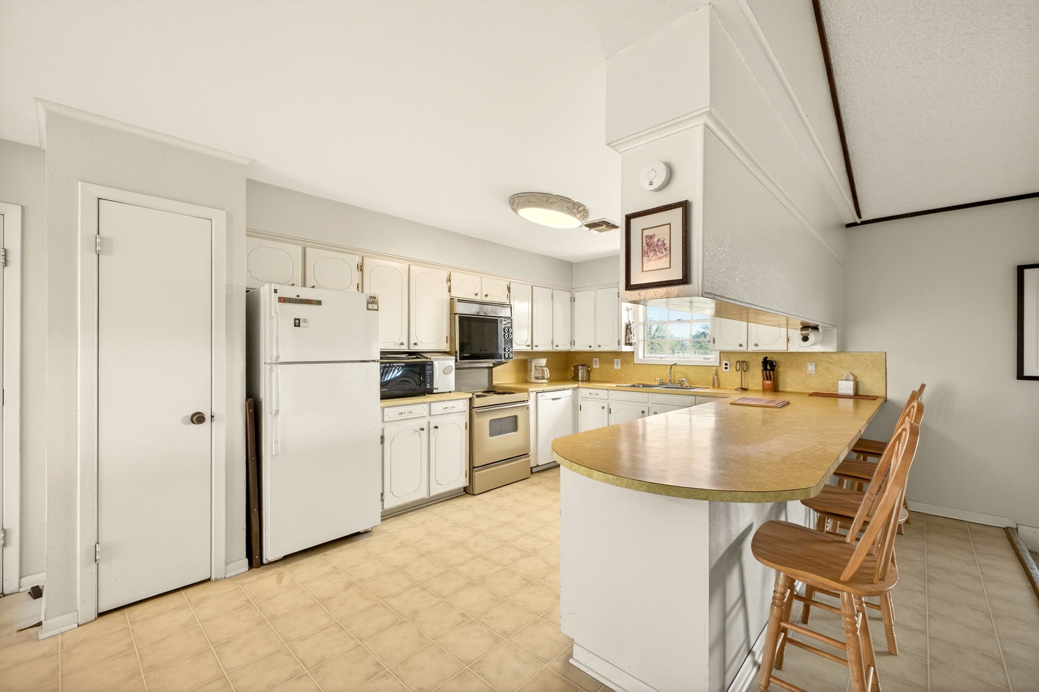 212 Halstedt Road La Grange, TX 78945 - Photo 8 of 40 a kitchen with refrigerator and white cabinets