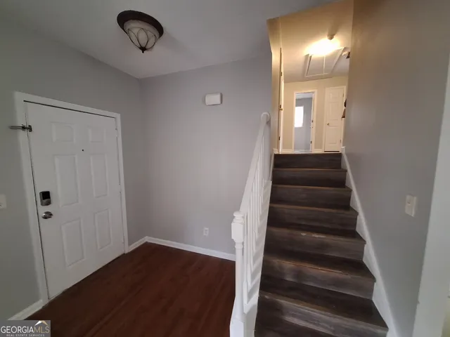 a view of a hallway with wooden floor and entryway